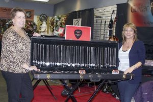 Hicksville’s Kathy O’Brien and Westbury’s Jeannemarie Graziano (right) with their guitar pick jewelry.