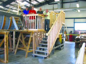 Bill Shephard of Plainview, Al Miller of Oyster Bay, Bob Larsen of Hicksville and Ed Peterson of Syosset trying out the staircase and viewing platform they built for visitors to get a good look inside the Ida May as she is being constructed