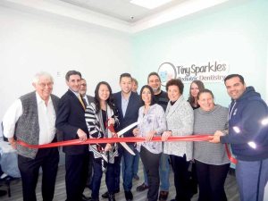 At the grand opening, from left: Jerry Rudnick (Chamber), Town Clerk Wayne Wink, Jerry Baldassaro (Chamber), Dr. Angie Chin, Katherine Crean (Chamber), Ricky La (manager,) Town Councilwoman Dina De Giorgio (BID), Mitch Schwartz (Chamber), Bobbie Polay (Chamber), Mari Gaudet (Port Washington News), Mariann Dalimonte (BID) and Richie the mailman