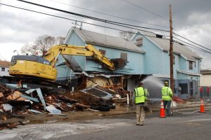 Crews knock down a vacant home in New Cassel. 