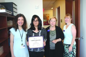 From left: Dr. Allison Reiss, head of the Inflammation Section at the Winthrop Research Institute, presents a Certificate of Appreciation from the Alzheimer’s Disease Resource Center to undergraduate researcher Hirra Arain, joined by Mary Ann Ragona, executive director and chief executive officer of the ADRC; and Michele Payne, director of programs, ADRC.