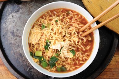 Ramen noodles in broth with chopsticks in a white bowl