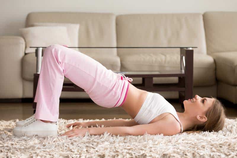 Woman in sportswear doing hip bridge exercise