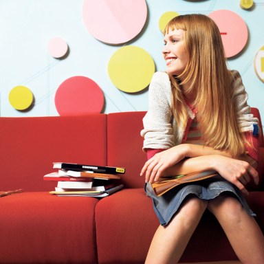 Young woman smiling sitting on a red sofa