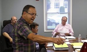 Hicksville Public Library employee Richard Vizza makes a point during the July meeting of the Board of Trustees. Vizza had distributed a copy of an opinion piece by JP Morgan CEO Jamie Dimon stating that the corporation would be raising the wages of its lowest paid employees. Listening, from left, are Joe Gangemella of the maintenance department, and trustees Carlos Munozospina and Bert Cunningham.