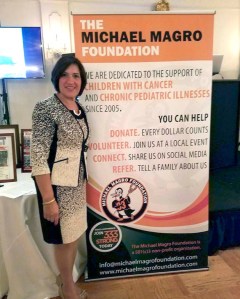 Terrie Magro stands next to a poster touting the Michael Magro Foundation. It was founded in memory of her 13-year-old son, a victim of cancer.
