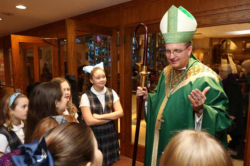 Bishop John Barres chats with St. Anne School students before Mass.