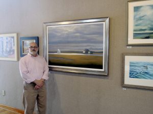 Al Trapani standing next to Daniel Pollera's "Bay House on Crow Island"
