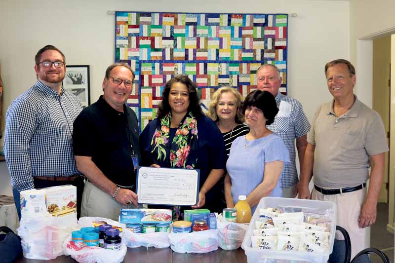 Assemblywoman Michaelle Solages (third from left) presented a $12,000 grant to LI Cares CEO Paule Pachter, joined by Chief Government Affairs Officer Michael Haynes, President of the Saint Vincent DuPaul Society at the Holy Name of Mary Roman Catholic Church Rosann Coppola and volunteers.