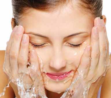 Cute woman wash her  face with water