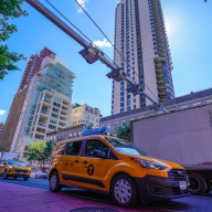 A taxi passes under an unused congestion pricing gantry