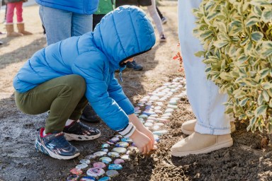 Central Boulevard students place their one-word rocks in a garden bed outside the school as a reminder of their goals this year.