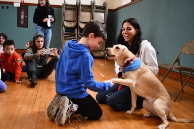 Detective Dionisia Mikalef with Kimi, a specialized therapy dog who provides comfort to crime victims and witnesses, at Manhasset's Munsey Park Elementary School