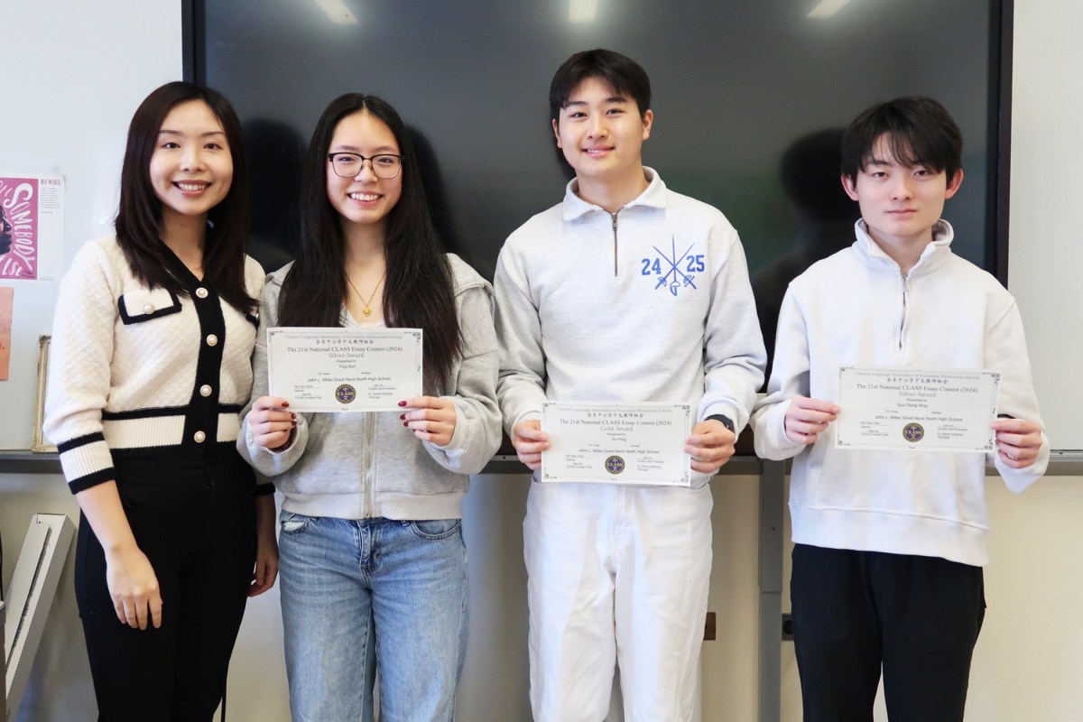 Pictured left to right, North High School Chinese teacher Pan Sam Chan congratulates award winners Ying Sun, Tony Ping, and Gary Ning