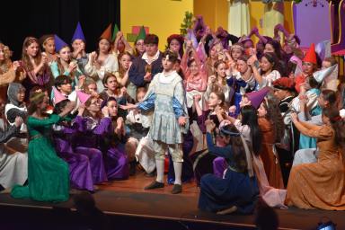 Prince Dauntless stands around subjects of the kingdom during Weber Middle School's performance of "Once Upon a Mattress."
