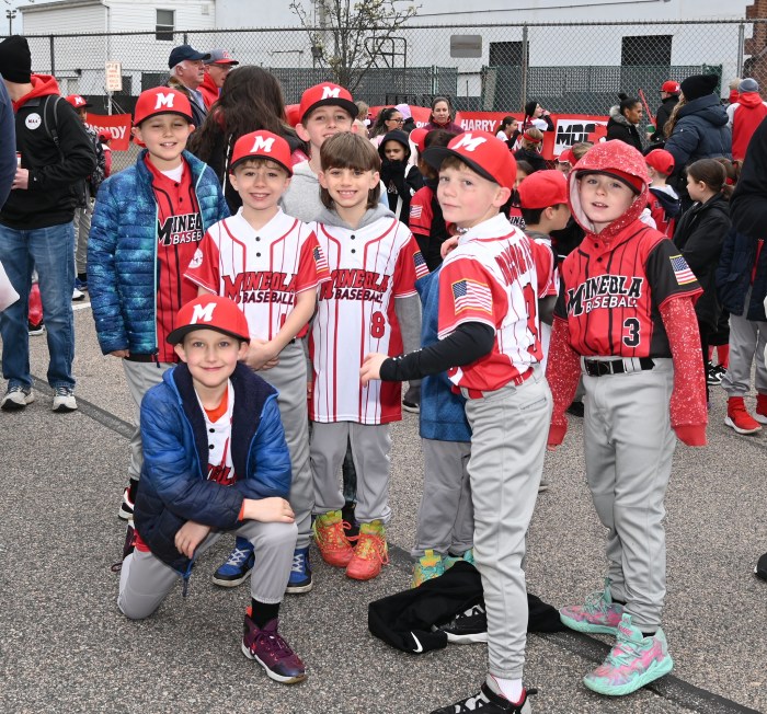Parade goers in baseball uniforms in Mineola's Little League parade
