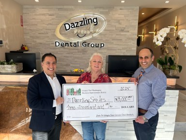 Hooman Neman (L.) and Armin Lalehzari (R.) of the Dazzling Smile Dental Group received a $3,000 grant from the Port Washington Business Improvement District, represented by Executive Director Holly Byrne (C.).