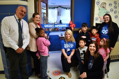 Herricks elementary schoolers pose in front of the new space with administrators.