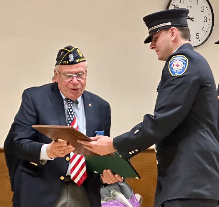Manhasset American Legion Commander John Iacono handing a plaque to Manhasset-Lakeville firefighter Michael Fiala