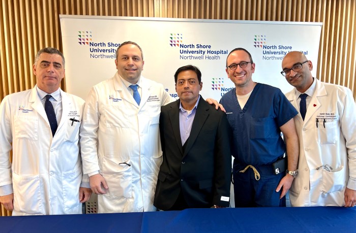 Northwell surgeons stand with Sergio Cestoni in the middle at a press conference after his surgery.