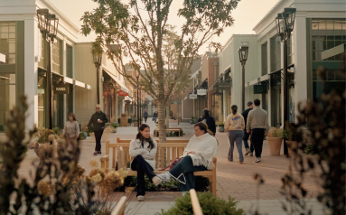 Shoppers sitting and walking through Belmont Park Village.