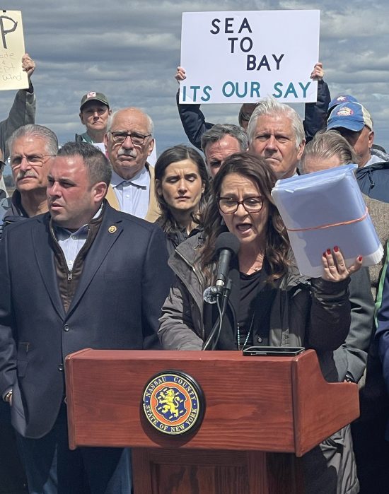 Christina Kramer of Protect Our Coasts Long Island New York holding a folder that she said has 20,000 signed petitions against the RAPID Act