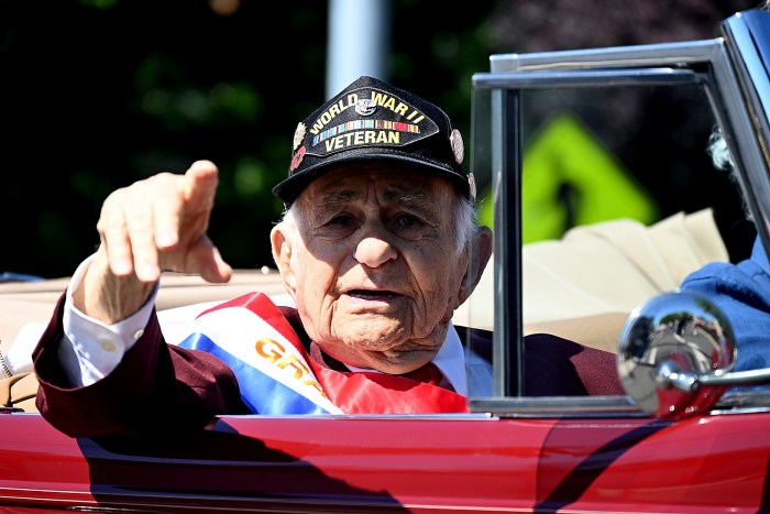 Great Neck Memorial Day parade Grand Marshal Harold Radish points to the crowd as he is driven along the parade route.
