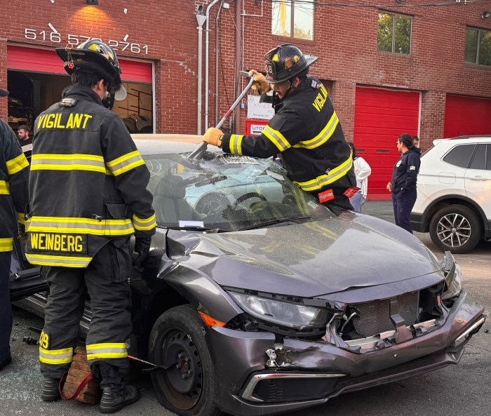 Members of the Great Neck Vigilant Fire Company remove a car's windshield at a rescue training event in Port Washington.