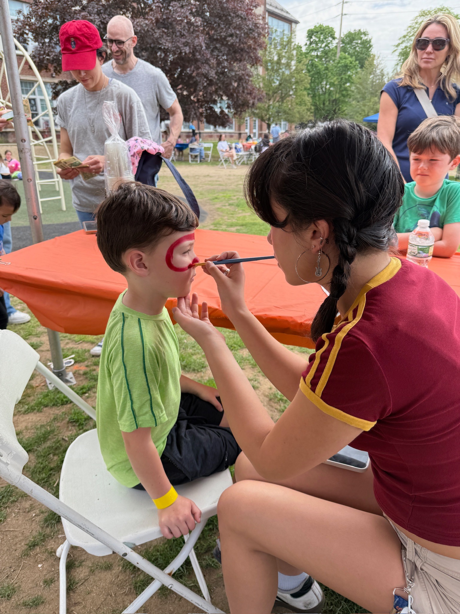 A child gets his face painted at the SCA Fair.