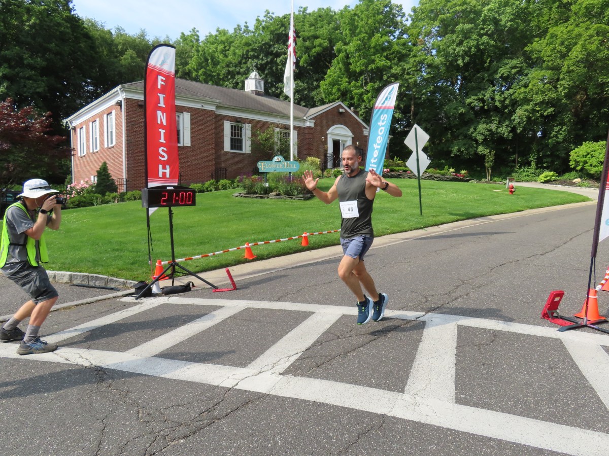 A runner crosses the finish line for the Katie Oppo Memorial 5K in Manhasset.