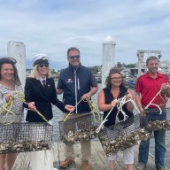 Mariann Dalimonte, Bonnie Doran, Ted Andel, Christina LoBuglio, and Mike Fiorentino release oysters in Manhasset Bay.