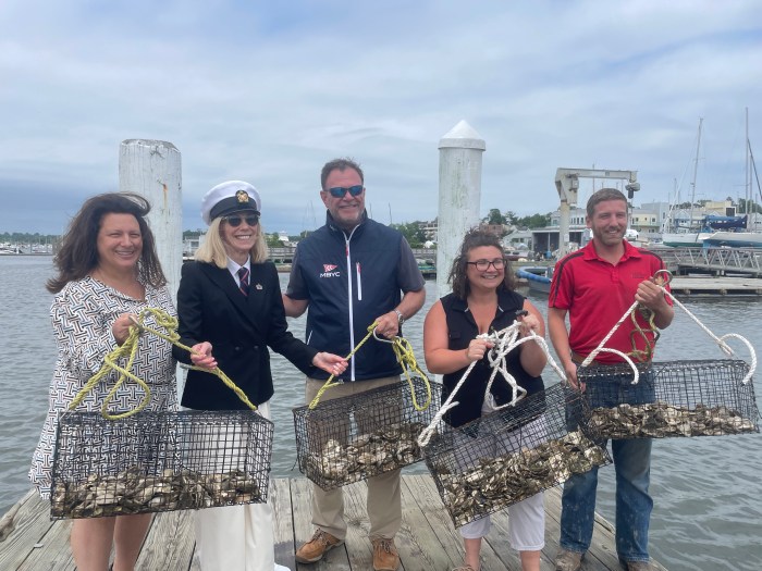 Mariann Dalimonte, Bonnie Doran, Ted Andel, Christina LoBuglio, and Mike Fiorentino release oysters in Manhasset Bay.