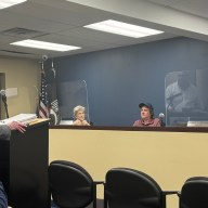 Bombay Foods owner Sanjiv Mody (standing left) and his lawyer, Michael Sahn (standing right), addressing the Village of Port Washington North Board of Trustees.