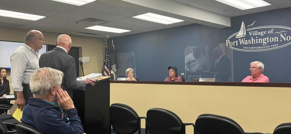 Bombay Foods owner Sanjiv Mody (standing left) and his lawyer, Michael Sahn (standing right), addressing the Village of Port Washington North Board of Trustees.