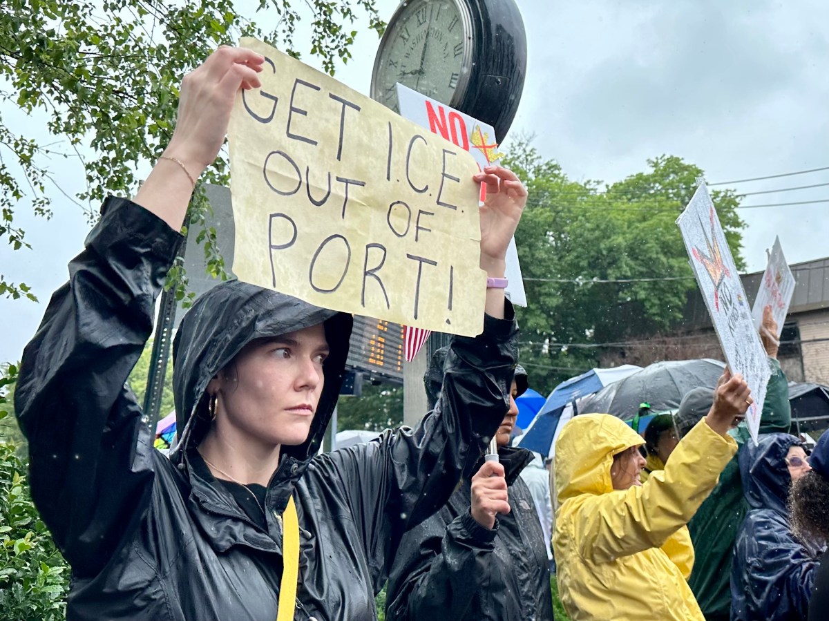A protester holds a sign reading "get ICE out of Port" at the No Kings rally in Port Washington.