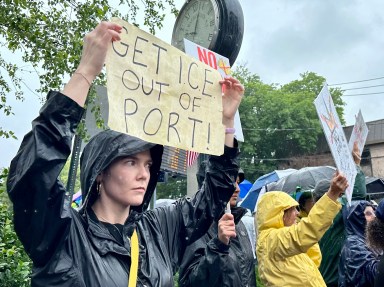 A protester holds a sign reading "get ICE out of Port" at the No Kings rally in Port Washington.