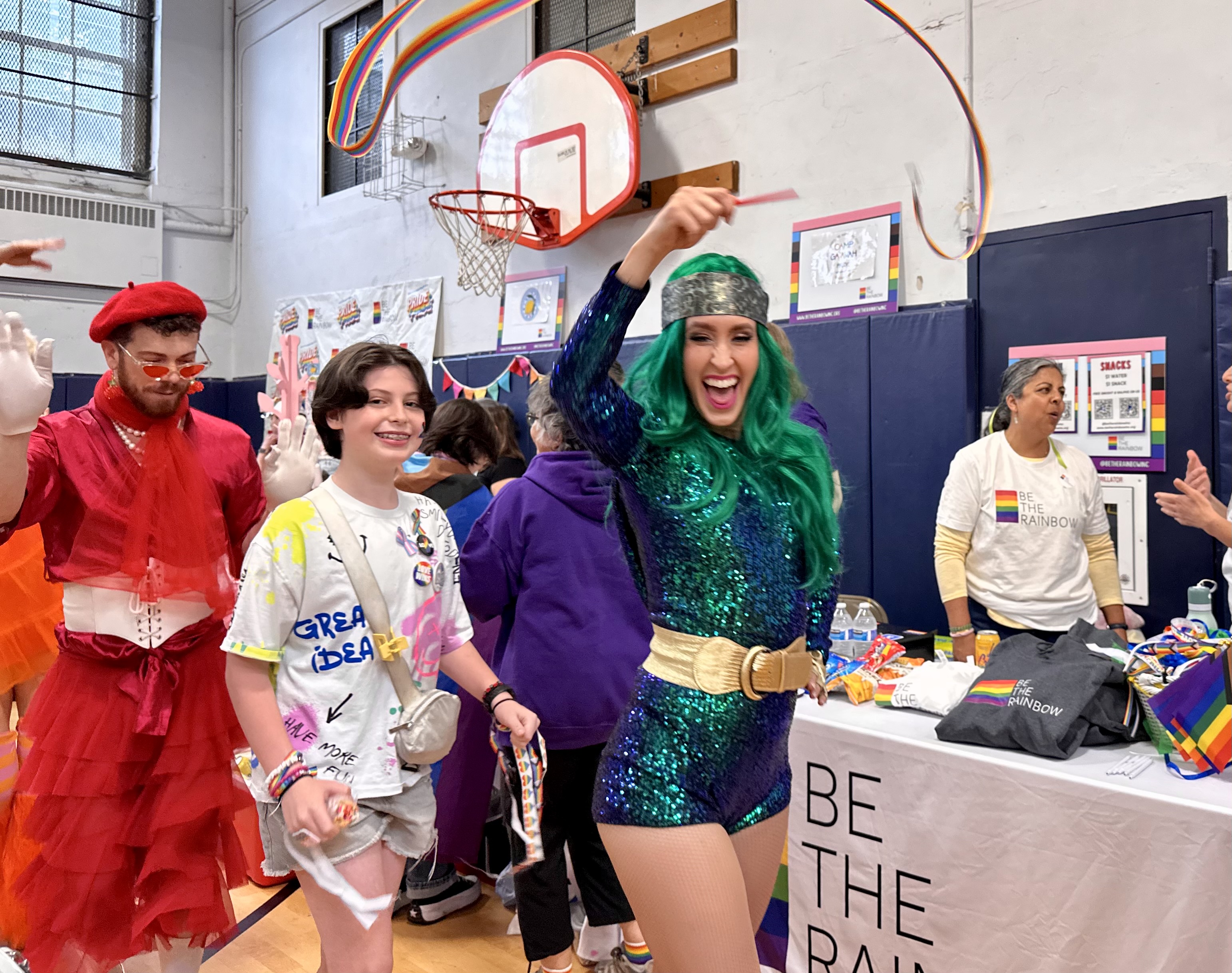 Performers and attendees march around the gym at the Pride celebration.