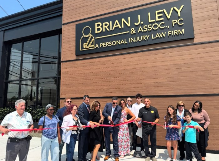 Brian Levy cuts the ribbon at the firm's 75 Jackson Ave. location.
