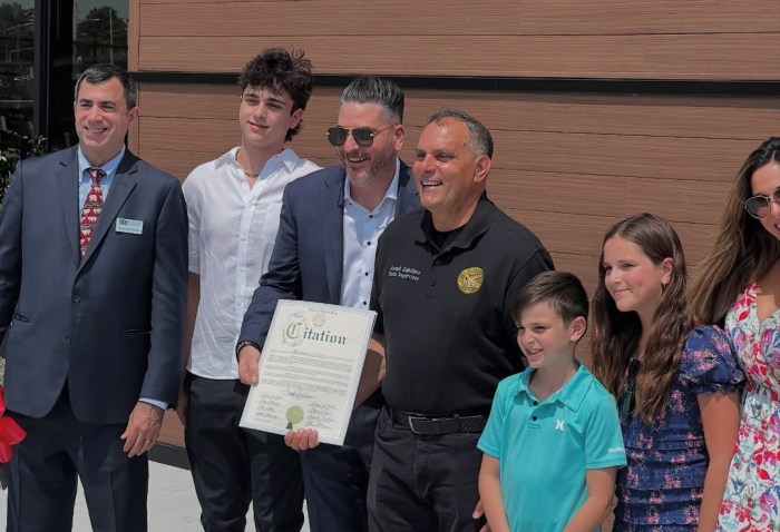 Brian Levy and Oyster Bay Town Supervisor Joseph Saladino (C.) celebrate the grand opening of Levy's new location in Syosset.