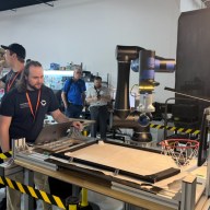Standard Bots employees demonstrate how to pick up items with the company's automation technology.