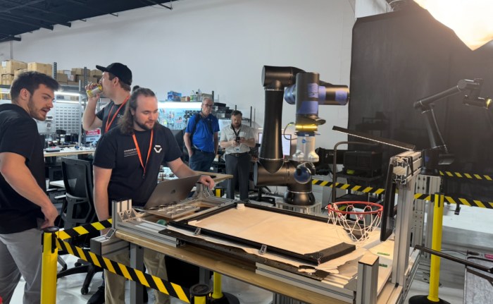 Standard Bots employees demonstrate how to pick up items with the company's automation technology.