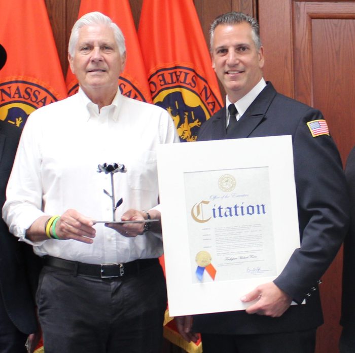 Bruce Blakeman honors firefighter Michael Farca for saving a Torah scroll from a fire in Roslyn.