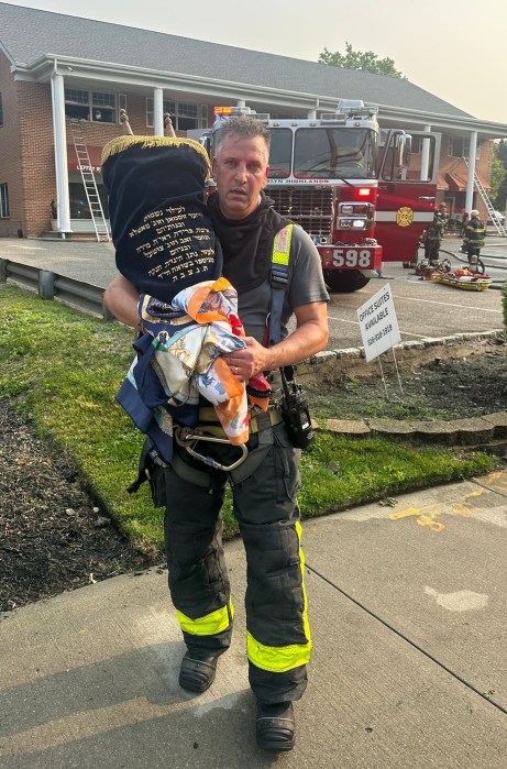 A Roslyn Highlands firefighter rescued a Torah scroll from a fire in Greenvale on Wednesday.
