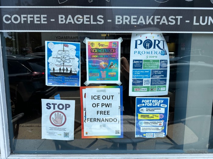 Signs in the window of Schmear Bagel & Cafe, where Fernando Mejia worked, saying "ICE get out of Port" and "Free Fernando."