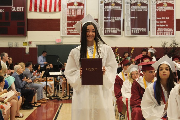 Senior receiving diploma at North Shore High School graduation ceremony.