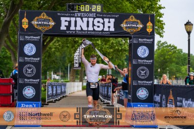 A racer crosses the finish line after completing the Great Gatsby Triathlon.