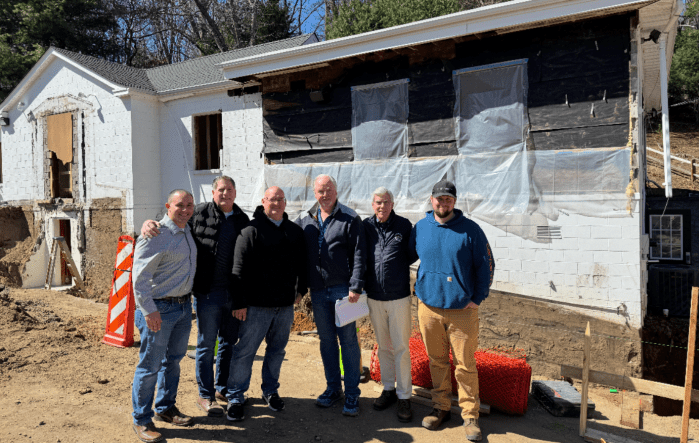 Elliot Conway (Second from R.) stands in front of the future village hall, located at 5701 Northern Boulevard.