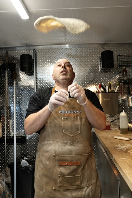Jim Serpico tossing dough for his pizza.