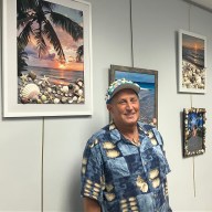 Michael Weinstein stands in front of his beach photography at the Jericho Library