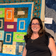 Patti Schust stands in front of one of her designs at a previous exhibition.